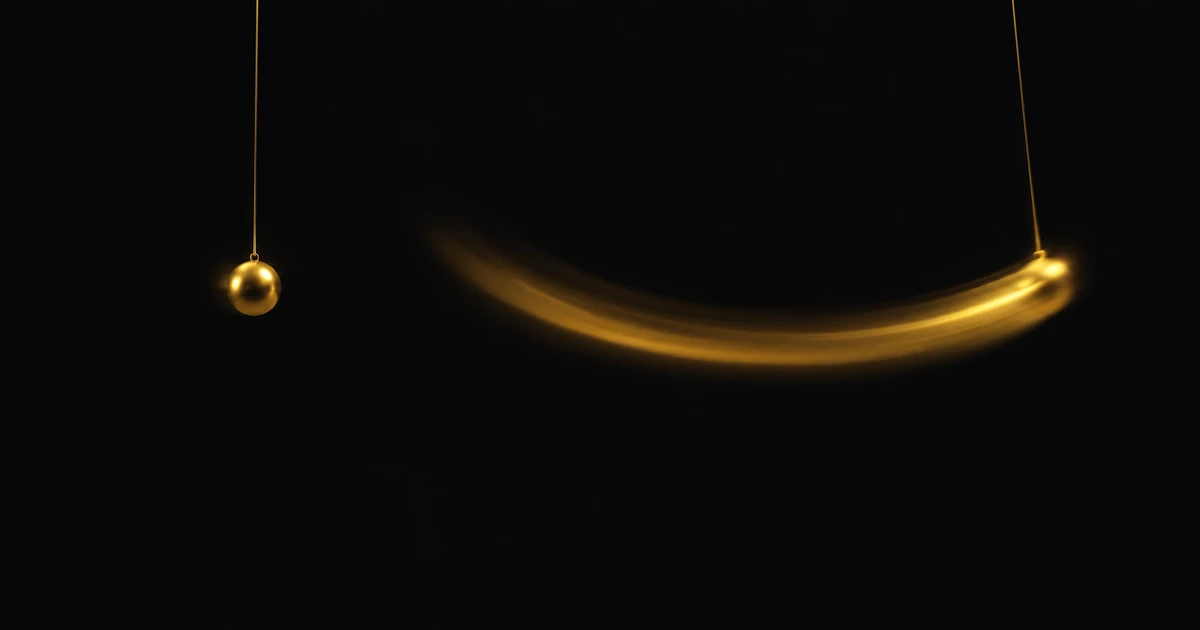 Two gold spheres on threads in the dark, one hanging almost still, the other smeared across a wide arc